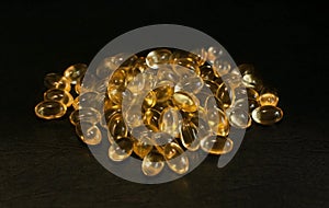 Evening primrose oil capsules on a black surface, with a shallow depth of field