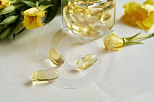 Evening primrose oil capsules with fresh blooming plant