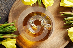 Evening primrose oil with evening primrose flowers on a table