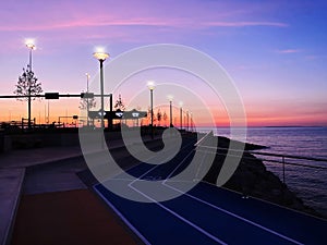 Evening promenade at pier city light people walking on horizon sunset pink sea and sky panorama Tallinn Estonia