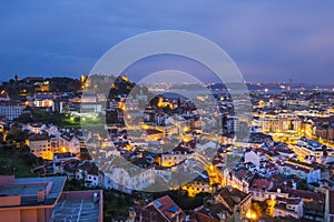 An evening scenic aerial view of the city of Lisbon illuminated by evening lights - the capital of Portugal, located on the hills