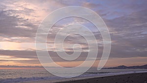 Evening by the sea in pastel colors. Clouds in the pink-blue sky.