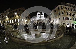 Evening shot - Tourists at Spanish Steps and a boat-shaped Fontana della Barcacciaon Piazza di Spagna in Rome, Italy, April, 2019