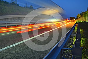 Evening shot of trucks doing transportation and logistics on a highway. Highway traffic - motion blurred truck on a