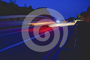 Evening shot of trucks doing transportation and logistics on a highway. Highway traffic - motion blurred truck on a