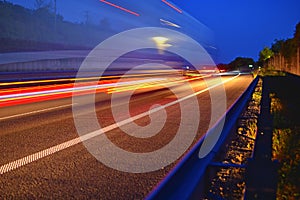 Evening shot of trucks doing transportation and logistics on a highway. Highway traffic - motion blurred truck on a highway motorw