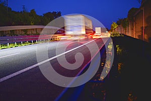 Evening shot of trucks doing transportation and logistics on a highway. Highway traffic - motion blurred truck on a highway motorw