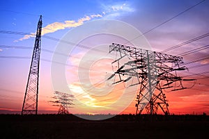 In the evening, the silhouette of high voltage towers