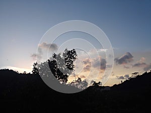 Evening sky dark mountain range trees clouds colourful