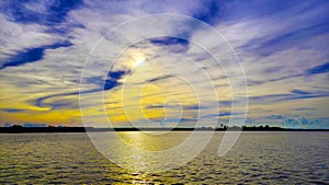 Evening sky with dramatic clouds over the lake and river and reflection in water with landscape of calm lake