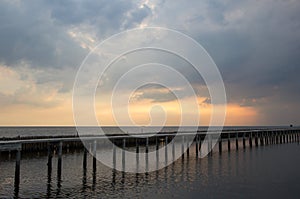 Evening sky,rows of bamboo sticks in the sea and cement bridge near Matchanu Shrine,Phanthai Norasing,Mueang Samut Sakhon District