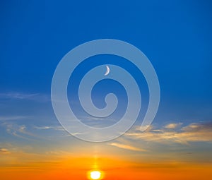 evening sun and halh moon on cloudy sky