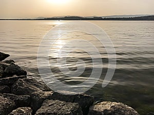 Evening sun and light over lake with reflections and peaceful ripples in Lake Murten in Switzerland