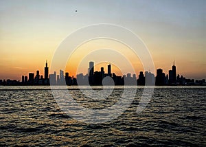 Evening sunset over Chicago silhouettes the skyline, as seen from Lake Michigan