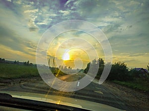 Evening sunset on the road through the car