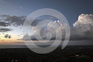 Evening sunset sky with colorful clouds over dark land. Panoramic skyscape photo