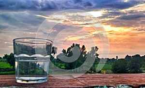 Evening sunset sky with drinking water glass image