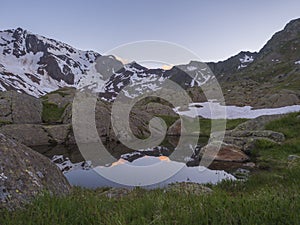 Evening sunset summer view from Bremer Hutte with lake from melting snow tongues and snow-capped moutain peaks, lush photo