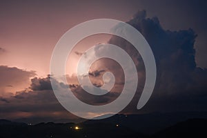 Evening thunderstorm with lightning in the mountains. Dramatic clouds during a thunderstorm pierce the light of
