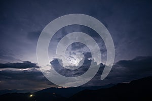 Evening thunderstorm with lightning in the mountains. Dramatic clouds during a thunderstorm pierce the light of