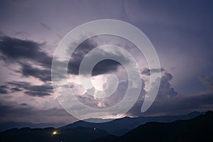Evening thunderstorm with lightning in the mountains. Dramatic clouds during a thunderstorm pierce the light of