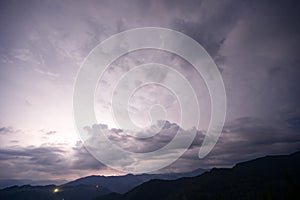Evening thunderstorm with lightning in the mountains. Dramatic clouds during a thunderstorm pierce the light of