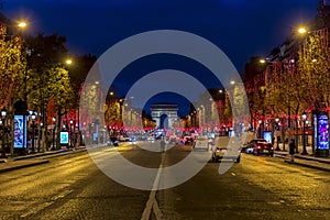 Evening traffic on Champs-Elysees in front of Arc de Triomphe Paris, France at Christmas Time