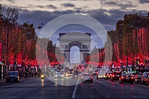 Evening traffic on Champs-Elysees in front of Arc de Triomphe Paris, France at Christmas Time