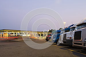 Evening truck stop lights of number of trucks in parking