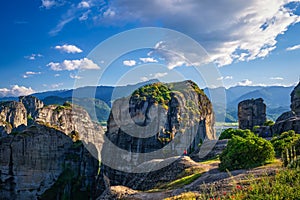 Evening in typical Meteora landscape, Greece. Massive rocks, cliffs, mountains and valley. Few tourist enjoy the view