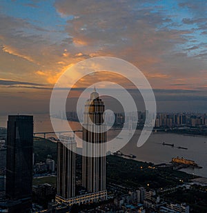 The evening, under the orange burning clouds, towering skyscrapers stand by the Yangtze River