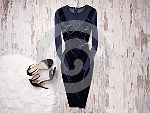 Evening velvet blue dress with chiffon, black shoes Wooden background, space for text. Fashion concept.