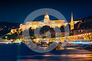 Evening view of Buda Castle with city lights and ship on the Dan