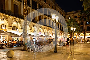 Evening view of bustling Placa Reial in Barcelona with cafes