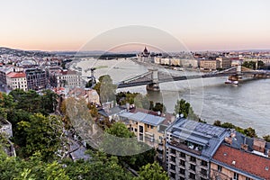 Evening view of Danube river with Szechenyi Lanchid bridge and Hungarian Parliament Building in Budapest, Hunga