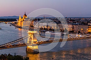 Evening view of Danube river with Szechenyi Lanchid bridge and Hungarian Parliament Building in Budapest, Hunga