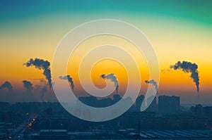 Evening view of the industrial landscape of the city with smoke emissions from chimneys at sunset photo