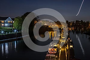 Teddington South West London, UK - Evening View of the River Thames with Boats and Airplane Trace Reflection photo