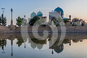 Evening view of a small pond and Dorut Tilavat complex with Kok Gumbaz mosque in Shahrisabz, Uzbekist