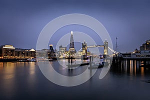 Evening view to the skyline of London with Tower Bridge and illuminated buildings