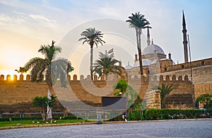 The evening walk at the Saladin Citadel with a view on sunset sky and the towering Alabaster Muhammad Ali Mosque behind the tall