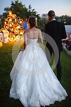 Evening wedding ceremony. The bride and Groom are on the background of the wedding arch.