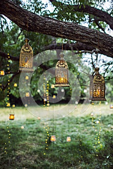 Evening wedding ceremony with a lot of vintage lanterns, lamps, candles
