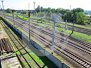 Evenly laid railroad rails crossing the frame diagonally. Railroad track, viewing platforms, rails for repairs, behind the fence.