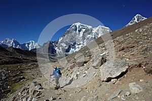 Everest trek, Man hiking in Himalayas with view of Tabuche Peak, Nepal