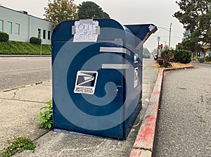 USPS postal drop box with hand written out of order sign on it in front of local Post Office