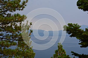 Evergreen Trees in Foreground of Lake and Mountains