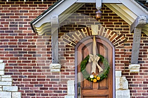 Evergreen Wreath on a Solid Oak Door with Small Orange and White Pumpkin Gourds