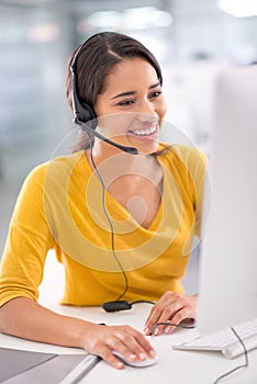 Every client is important to her. Shot of a young customer service representative wearing a headset while sitting by her