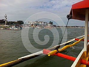Outtrigger boat departing Lucap port for the sightseeing tour of Hundreed Islands National Park, Alaminos, Philippinnes photo